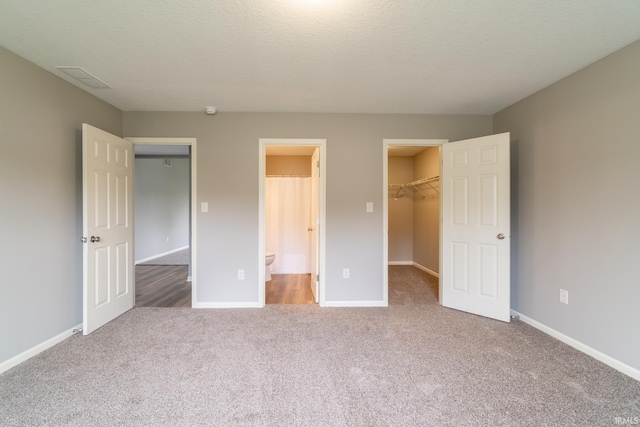 3827 Winter Raven Trl, Fort Wayne, IN 46818 - unfurnished bedroom with a spacious closet, carpet floors, a closet, and baseboards