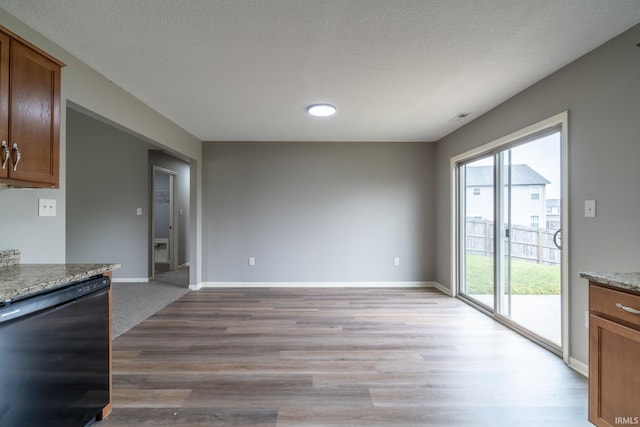 3827 Winter Raven Trl, Fort Wayne, IN 46818 - kitchen featuring black dishwasher, light wood-style floors, baseboards, light stone counters, and a textured ceiling