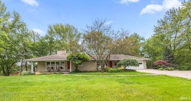 1437 W State Road 56th Rd, Jasper, IN 47546 - view of front facade featuring concrete driveway, a chimney, a garage, and a front yard
