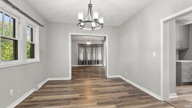 524 Byron St, Huntington, IN 46750 - unfurnished dining area featuring a chandelier, wood finished floors, and baseboards