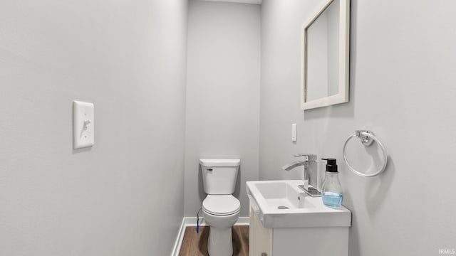 524 Byron St, Huntington, IN 46750 - bathroom featuring toilet, wood finished floors, vanity, and baseboards
