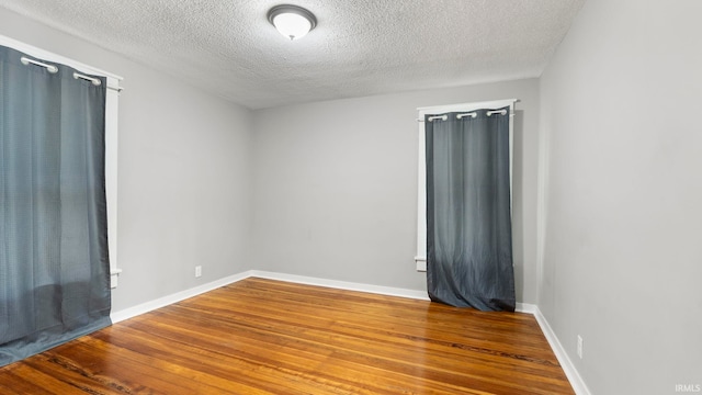 524 Byron St, Huntington, IN 46750 - spare room featuring a textured ceiling, wood finished floors, and baseboards