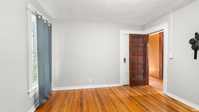 524 Byron St, Huntington, IN 46750 - empty room featuring hardwood / wood-style flooring, a textured ceiling, and baseboards