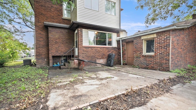 524 Byron St, Huntington, IN 46750 - rear view of property featuring cooling unit, brick siding, and a patio area