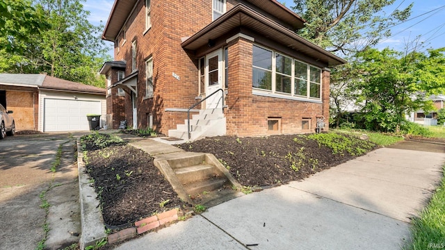 524 Byron St, Huntington, IN 46750 - view of side of home featuring brick siding, a garage, driveway, and an outbuilding