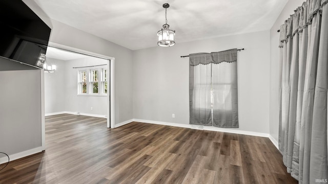 524 Byron St, Huntington, IN 46750 - unfurnished room featuring a chandelier, wood finished floors, and baseboards