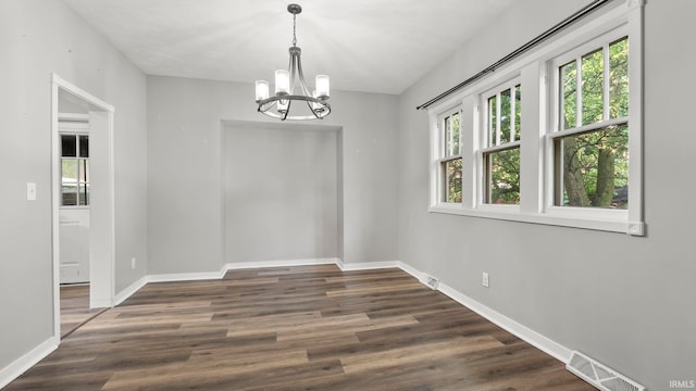 524 Byron St, Huntington, IN 46750 - unfurnished dining area with a chandelier, baseboards, and wood finished floors