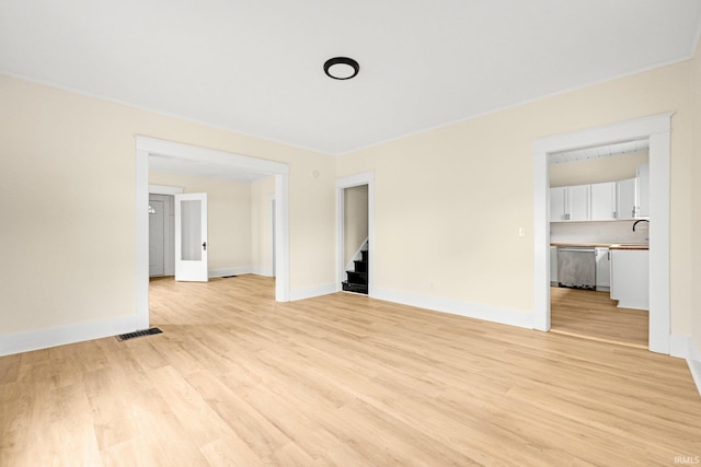 110 N Sheridan St, Kendallville, IN 46755 - unfurnished living room featuring stairs, light wood-style flooring, and baseboards