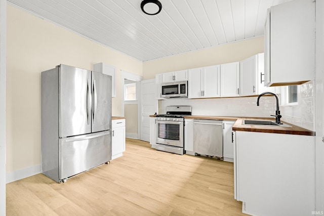 110 N Sheridan St, Kendallville, IN 46755 - kitchen with stainless steel appliances, a sink, butcher block counters, light wood-style floors, and wood ceiling