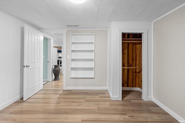 1310 Oak Ave, Lafayette, IN 47905 - empty room featuring built in shelves, crown molding, light wood-type flooring, and baseboards