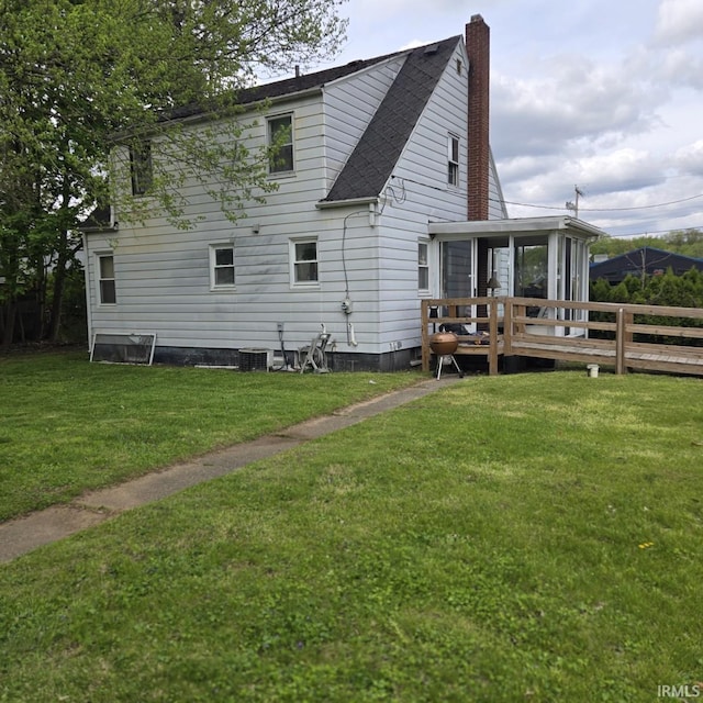 11544 Lincolnway Hwy, Osceola, IN 46561 - back of property featuring a sunroom, a chimney, a shingled roof, and central AC unit