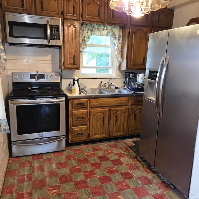 11544 Lincolnway Hwy, Osceola, IN 46561 - kitchen with stainless steel appliances, dark flooring, a sink, a chandelier, and backsplash