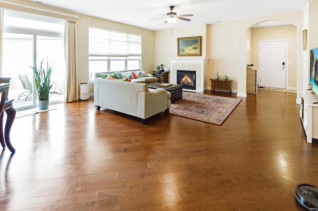 1632 Solemar Dr, West Lafayette, IN 47906 - living room featuring ceiling fan, arched walkways, a tiled fireplace, and wood finished floors