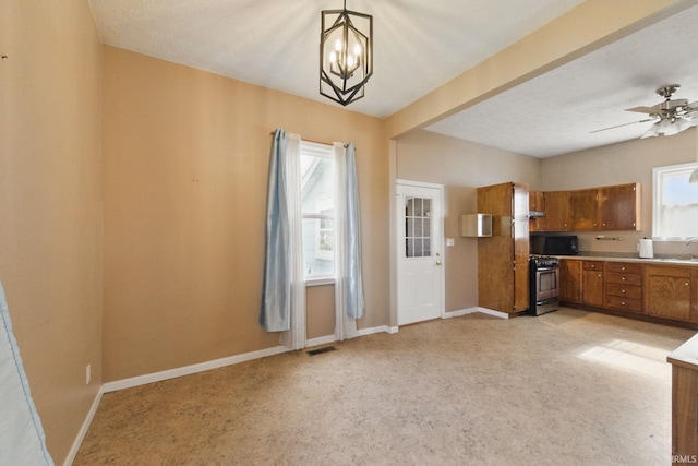 2000 Vinton St, Lafayette, IN 47904 - kitchen featuring brown cabinetry, gas stove, a sink, light countertops, and light carpet