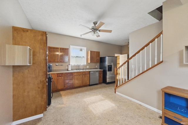 2000 Vinton St, Lafayette, IN 47904 - kitchen featuring appliances with stainless steel finishes, brown cabinetry, a sink, ceiling fan, and light countertops