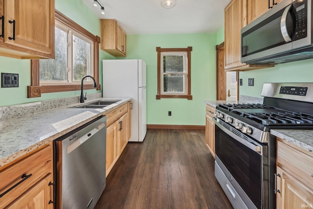 2509 Main St, Lafayette, IN 47904 - kitchen featuring stainless steel appliances, a sink, dark wood-style floors, light stone countertops, and baseboards