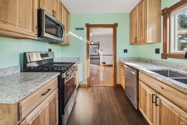 2509 Main St, Lafayette, IN 47904 - kitchen with stainless steel appliances, dark wood finished floors, light stone counters, and baseboards