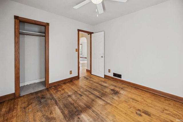 2509 Main St, Lafayette, IN 47904 - unfurnished bedroom with baseboards, hardwood / wood-style flooring, a closet, a ceiling fan, and arched walkways