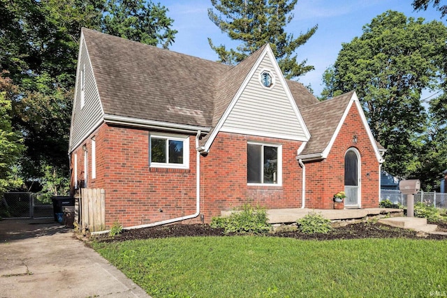 2509 Main St, Lafayette, IN 47904 - tudor house featuring brick siding, roof with shingles, and a gate