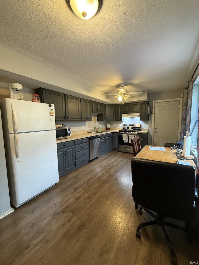703 Downey Ave, Mishawaka, IN 46544 - kitchen with stainless steel appliances, gray cabinets, dark wood-style floors, a sink, and light countertops