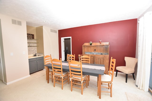 9763 S Harbour Pointe Dr Unit 34, Bloomington, IN 47401 - dining space featuring bar area, light colored carpet, and baseboards