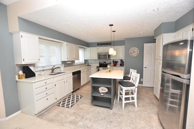 9763 S Harbour Pointe Dr Unit 34, Bloomington, IN 47401 - kitchen featuring stainless steel appliances, a sink, light countertops, a center island, and white cabinetry
