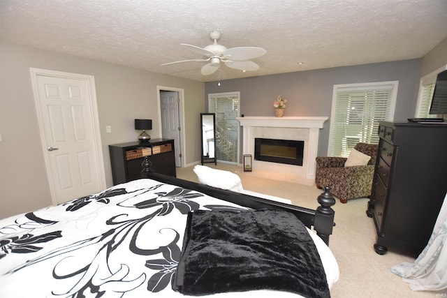 9763 S Harbour Pointe Dr Unit 34, Bloomington, IN 47401 - bedroom with carpet, a textured ceiling, a high end fireplace, and ceiling fan