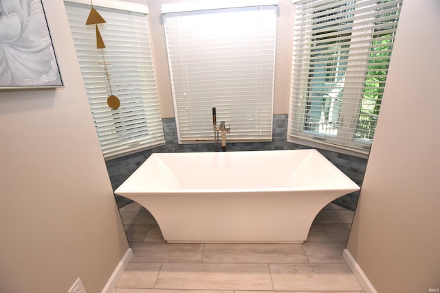 9763 S Harbour Pointe Dr Unit 34, Bloomington, IN 47401 - bathroom featuring a soaking tub and baseboards