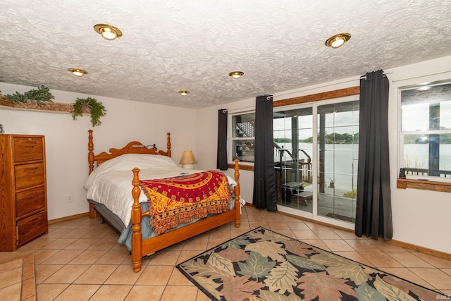 536 Garfield St, Osceola, IN 46561 - bedroom with access to exterior, a textured ceiling, light tile patterned floors, and baseboards