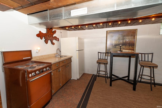 536 Garfield St, Osceola, IN 46561 - kitchen featuring electric stove, freestanding refrigerator, a sink, light countertops, and brown cabinetry