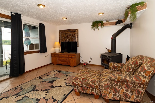 536 Garfield St, Osceola, IN 46561 - living area featuring tile patterned flooring, a wood stove, a textured ceiling, and baseboards