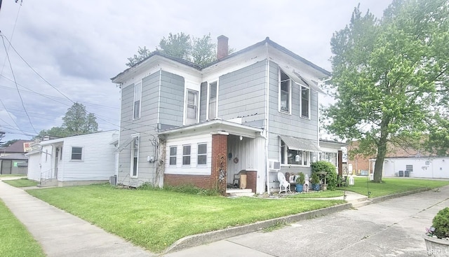 146 W Washington St, Parker City, IN 47368 - view of front of property with a front lawn, brick siding, and a chimney