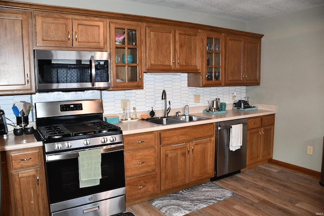 2329 Glenwood Ave, Fort Wayne, IN 46805 - kitchen with stainless steel appliances, a sink, brown cabinets, dark wood finished floors, and light countertops