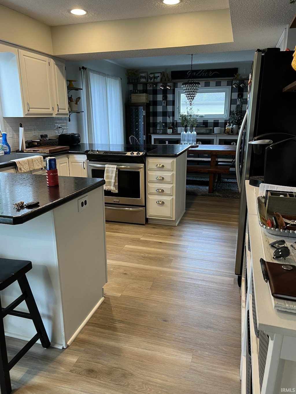 1130 Skyline Pass, Fort Wayne, IN 46825 - kitchen with stainless steel electric range oven, dark countertops, a peninsula, light wood-style floors, and recessed lighting