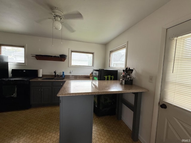 219 S 3rd St, Gas City, IN 46933 - kitchen featuring a sink, light flooring, a ceiling fan, and a peninsula