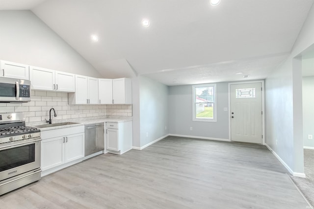 4280 S 1170 E, Lagrange, IN 46761 - kitchen featuring appliances with stainless steel finishes, a sink, light countertops, white cabinetry, and backsplash