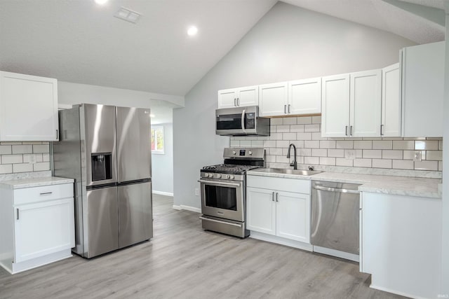 4280 S 1170 E, Lagrange, IN 46761 - kitchen with appliances with stainless steel finishes, a sink, light countertops, white cabinets, and high vaulted ceiling
