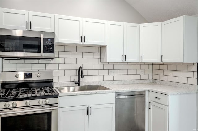 4280 S 1170 E, Lagrange, IN 46761 - kitchen featuring stainless steel appliances, a sink, lofted ceiling, backsplash, and white cabinets
