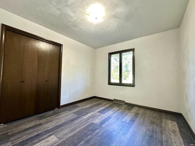 618 N Kluemper Rd, Jasper, IN 47546 - unfurnished bedroom featuring dark wood-style floors, baseboards, and a closet