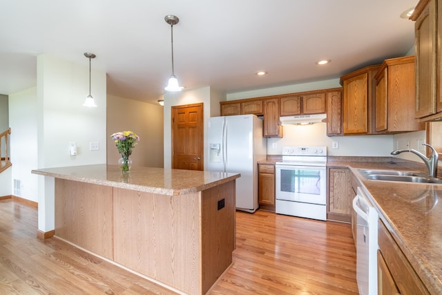 3775 W Columbia St, Columbia City, IN 46725 - kitchen featuring white appliances, a sink, under cabinet range hood, light wood-type flooring, and hanging light fixtures