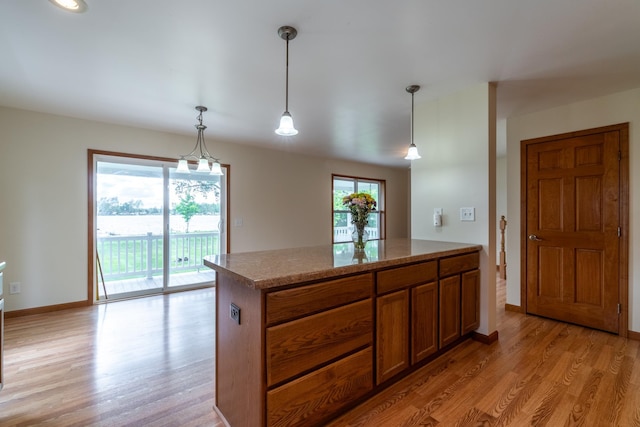 3775 W Columbia St, Columbia City, IN 46725 - kitchen featuring brown cabinets, light wood-style floors, decorative light fixtures, and baseboards