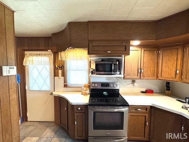 1505 S 3rd St, Clinton, IN 47842 - kitchen featuring appliances with stainless steel finishes, light countertops, light tile patterned floors, and brown cabinetry