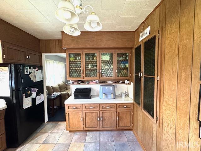 1505 S 3rd St, Clinton, IN 47842 - kitchen featuring freestanding refrigerator, a chandelier, light countertops, brown cabinetry, and glass insert cabinets