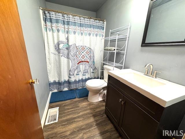 1505 S 3rd St, Clinton, IN 47842 - full bathroom with vanity, toilet, wood finished floors, and a shower with shower curtain