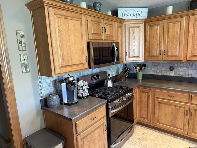 10123 Consta Verde Commons, Leo, IN 46765 - kitchen with appliances with stainless steel finishes, dark countertops, tasteful backsplash, and brown cabinets