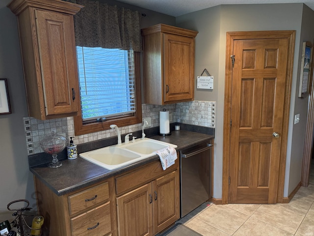10123 Consta Verde Commons, Leo, IN 46765 - kitchen featuring stainless steel dishwasher, a sink, dark countertops, decorative backsplash, and brown cabinetry
