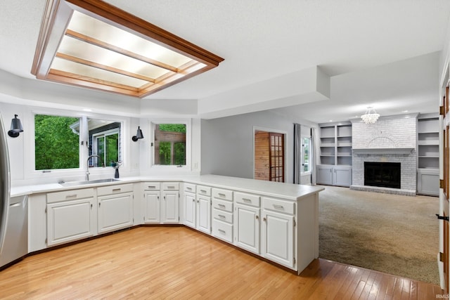 2814 Meadow Strm, Fort Wayne, IN 46825 - kitchen with a sink, a peninsula, white cabinets, light wood-style floors, and light countertops