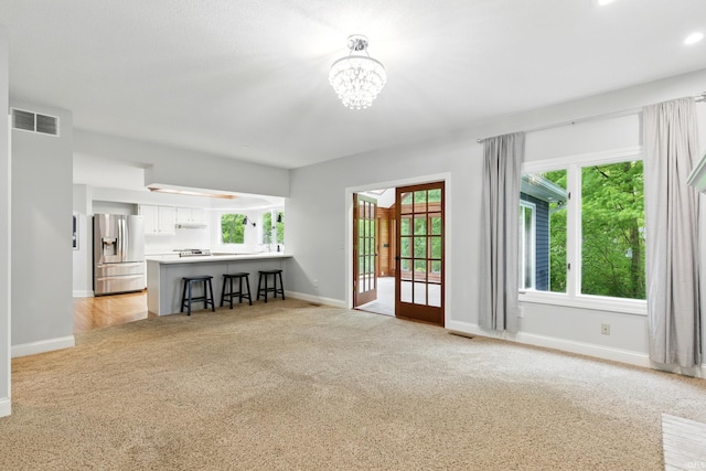 2814 Meadow Strm, Fort Wayne, IN 46825 - living room featuring light carpet, baseboards, and a chandelier