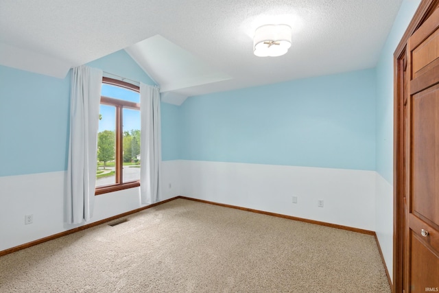 2814 Meadow Strm, Fort Wayne, IN 46825 - carpeted empty room with vaulted ceiling, baseboards, and a textured ceiling