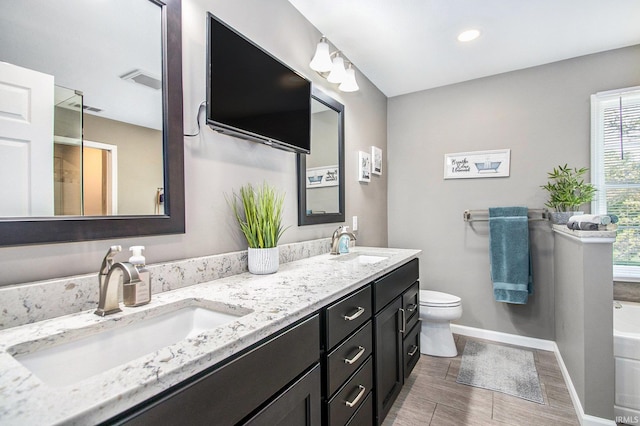 54453 Sagewood Dr, Mishawaka, IN 46545 - full bath with double vanity, baseboards, toilet, a bath, and wood finished floors